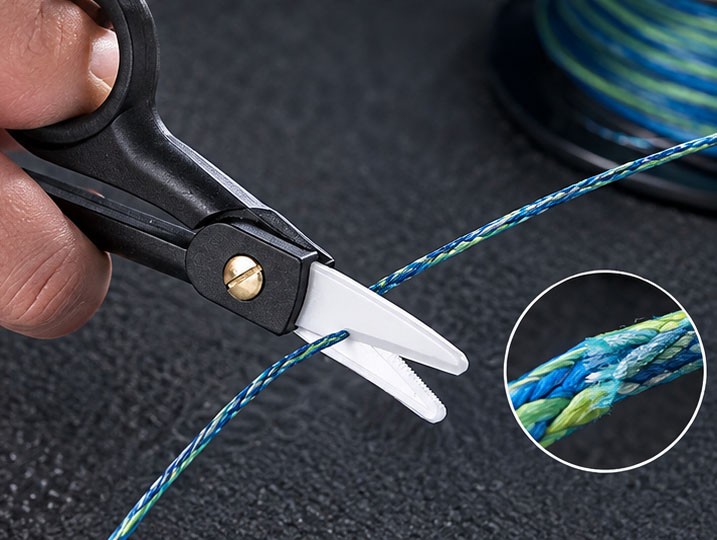 White serrated ceramic blades cutting braided PE fishing line